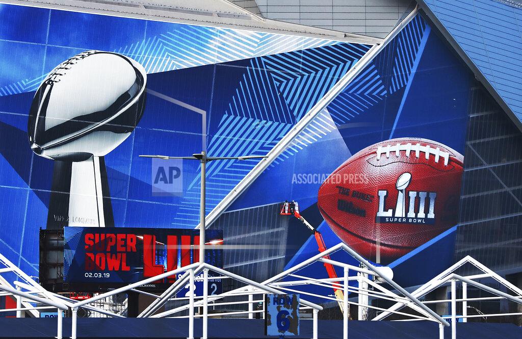 Curtis Compton In this Jan. 17, 2019 photo, workers use a lift to install a Super Bowl 53 wrap on the outside of Mercedes-Benz Stadium as it is transformed for the big NFL football game in Atlanta. Kraft Heinz’ frozen-food brand Devour is trying to make waves during its Super Bowl debut with an ad taking a humorous jab at one man’s “frozen food porn addiction.” Super Bowl ads have long used raunchiness and sex stand out during the Super Bowl, advertising’s biggest stage. But the approach runs the risk of offending the audience. (Curtis Compton/Atlanta Journal-Constitution via AP, File)
