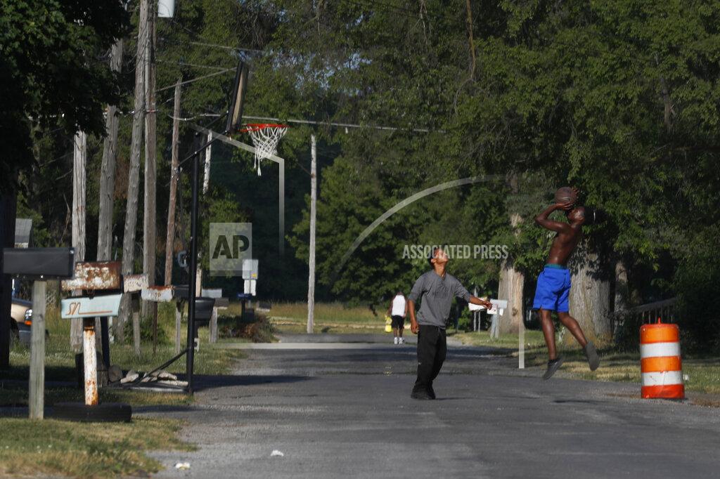 Charles Rex Arbogast Youths play a game of one-on-one basketball Monday, June 29, 2020, on a neighborhood street on the impoverished east side of Saginaw, Mich. Saginaw has battled crime, inadequate educational options and food deserts that have largely impacted the city’s Black and Latino residents. (AP Photo/Charles Rex Arbogast)