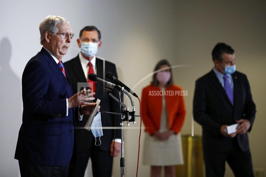 Senate Majority Leader Mitch McConnell of Ky., left, speaks at a news conference on Capitol Hill in Washington, Tuesday, May 12, 2020. Standing behind McConnell are Sen. John Barrasso, R-Wyo., from back left, Sen. Joni Ernst, R-Iowa, and Sen. Todd Young, R-Ind. (AP Photo/Patrick Semansky)