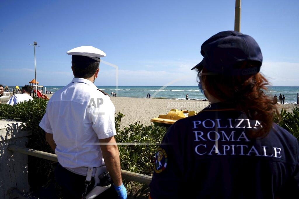 Italian police carry out anti-gathering checks along Ostia beach, near Rome, Sunday, May 24, 2020. Europeans and Americans soaked up the sun where they could, taking advantage of the first holiday weekend since coronavirus restrictions were eased, while European governments grappled with how and when to safely let in foreign travelers to salvage the vital summer tourist season. Italy, which plans to open regional and international borders on June 3 in a bid to boost tourism, is only now allowing locals back to beaches in their own regions — with restrictions. (AP Photo/Andrew Medichini)