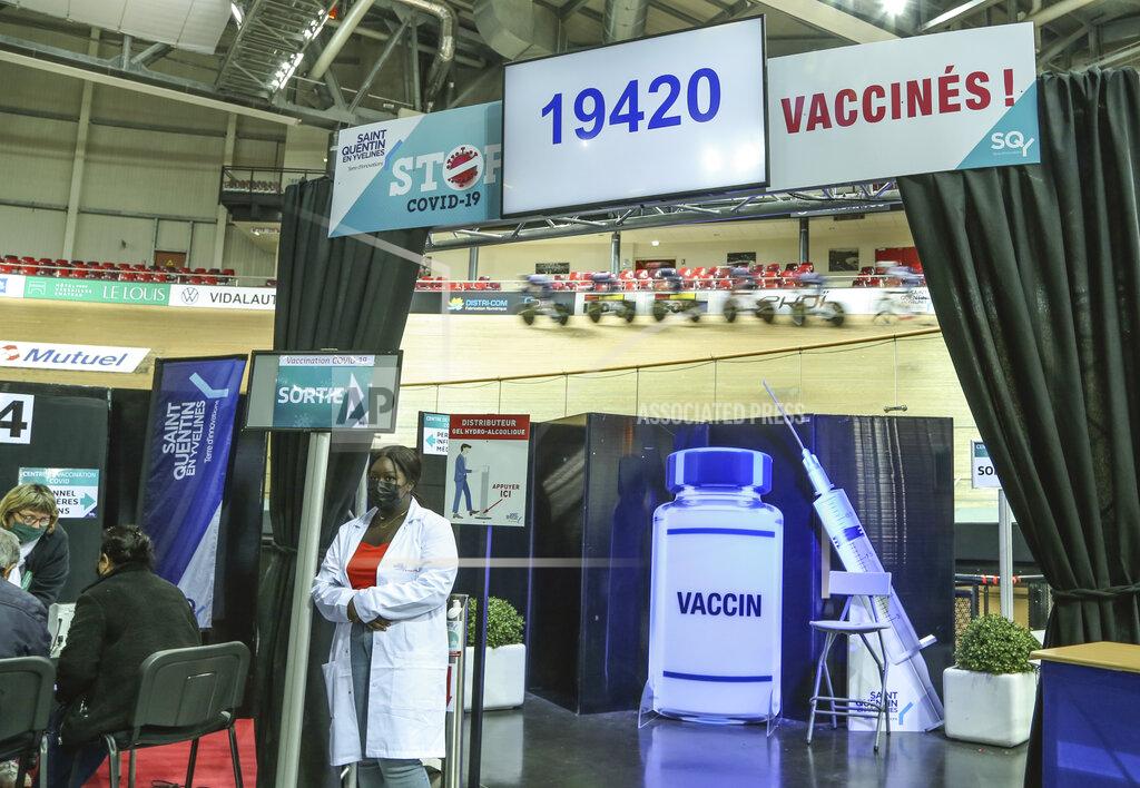 John Leicester Riders train at the National Velodrome at Saint-Quentin-en-Yvelines, west of Paris, Saturday, March 27, 2021, that has been transformed into a mass vaccination center. Saturday marked the first day in France of vaccination for healthy people aged 70 and above. (AP Photo/John Leicester)