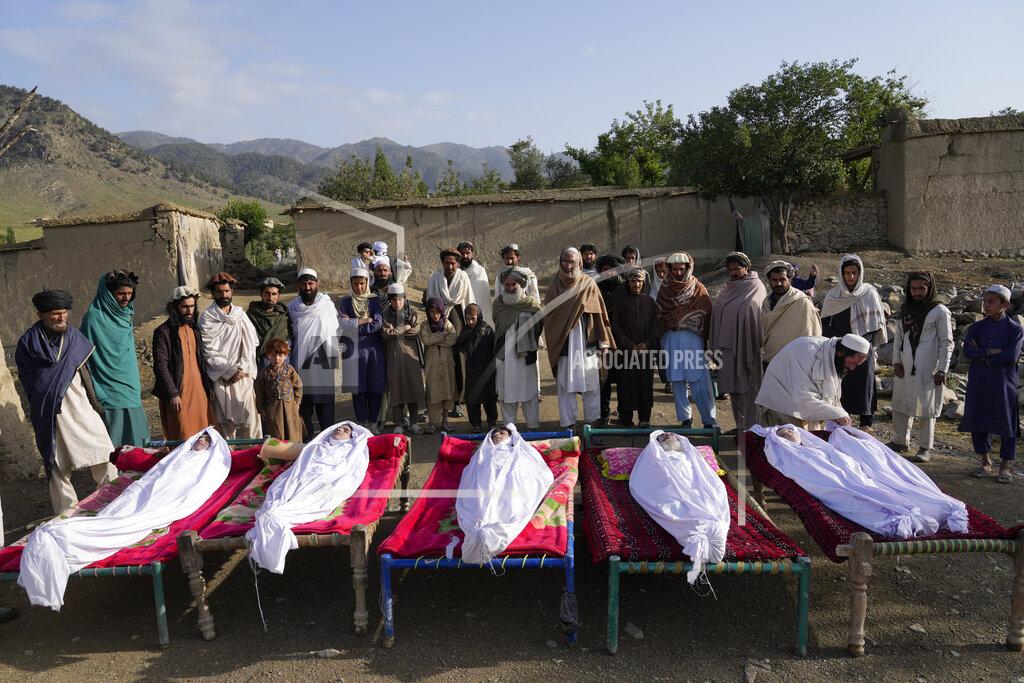 Ebrahim Noroozi Men stand around the bodies of people killed in an earthquake in Gayan village, in Paktika province, Afghanistan, Thursday, June 23, 2022. A powerful earthquake struck a rugged, mountainous region of eastern Afghanistan early Wednesday, flattening stone and mud-brick homes in the country's deadliest quake in two decades, the state-run news agency reported. (AP Photo/Ebrahim Nooroozi)