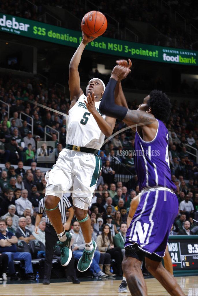 Michigan State's Cassius Winston, left, goes up for a layup against Northwestern's Vic Law during the first half of an NCAA college basketball game, Wednesday, Jan. 2, 2019, in East Lansing, Mich. (AP Photo/Al Goldis)