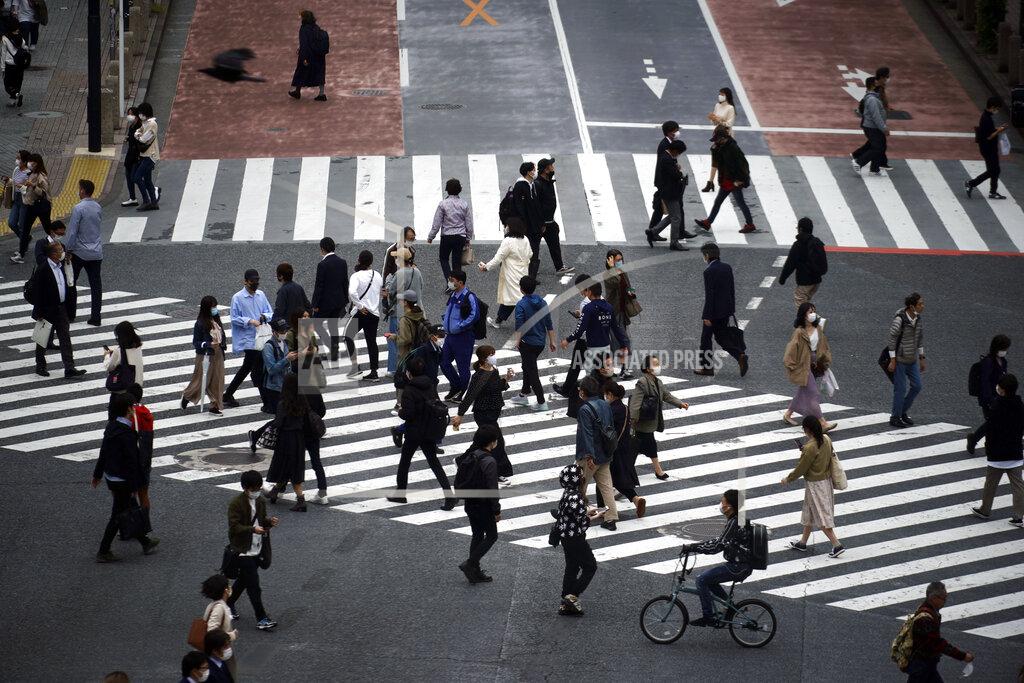 Eugene Hoshiko Pedestrians pass a street crossing Friday, May 22, 2020, in Tokyo. Tokyo is still under a coronavirus state of emergency until the end of May though there have been no hard lockdowns. (AP Photo/Eugene Hoshiko)