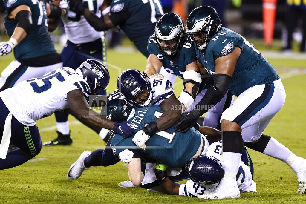 Derik Hamilton Philadelphia Eagles' Carson Wentz (11) is tackled by Seattle Seahawks' Carlos Dunlap (43), Jarran Reed (90) and Benson Mayowa (95) during the first half of an NFL football game, Monday, Nov. 30, 2020, in Philadelphia. (AP Photo/Derik Hamilton)
