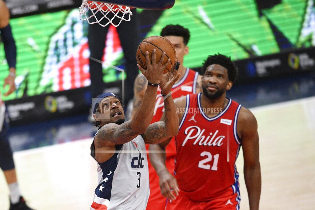 Nick Wass Washington Wizards guard Bradley Beal (3) goes to the basket past Philadelphia 76ers center Joel Embiid (21) during the first half of an NBA basketball game Friday, March 12, 2021, in Washington. (AP Photo/Nick Wass)