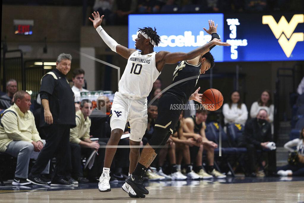 Kathleen Batten West Virginia guard Malik Curry (10) react as Oakland guard Jalen Moore (34) defends during the second half of an NCAA college basketball game in Morgantown, W.Va., Tuesday, Nov. 9, 2021. (AP Photo/Kathleen Batten)