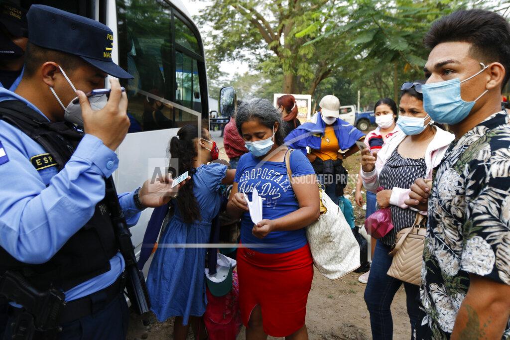Delmer Martinez Police check people's documents before allowing them to continue their journey toward the Guatemalan border, on the highway leading to Santa Barbara, after they left San Pedro Sula, Honduras, before dawn Friday, Jan. 15, 2021. The migrants leave with little certainty about how far they will make it, as regional governments appeared more united than ever in stopping their progress. (AP Photo/Delmer Martinez)