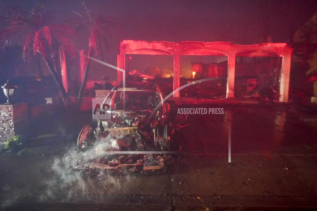 Marcio J. Sanchez A car smolders in front of a destroyed home during a wildfire Wednesday, May 11, 2022, in Laguna Niguel, Calif. (AP Photo/Marcio J. Sanchez)