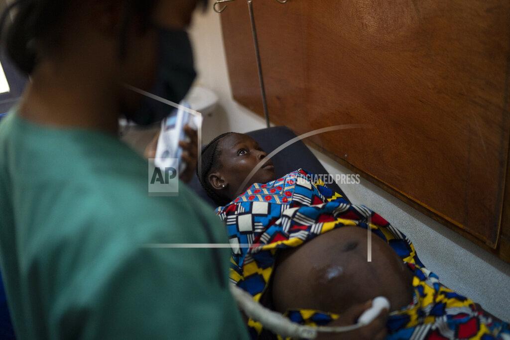 Leo Correa Mariama is attended to in a health unit where several women look for assistance for their prenatal care in Koidu, district of Kono, Sierra Leone, Tuesday, Nov. 24, 2020. Mariama, who estimates her age at 17, had left her remote village near the border with Guinea to live with an aunt in Koidu and attend school. Then in April a 28-year-old man in their compound expressed interest in her. It took a month for Mariama to say yes over her aunt's threats to send her back to her village, where her father is struggling to feed two wives and 10 other children and her mother would be embarrassed by her return. If she has a daughter, one thing is certain, she says: “I will not give my child to anybody. I will take care of her.” (AP Photo/Leo Correa)