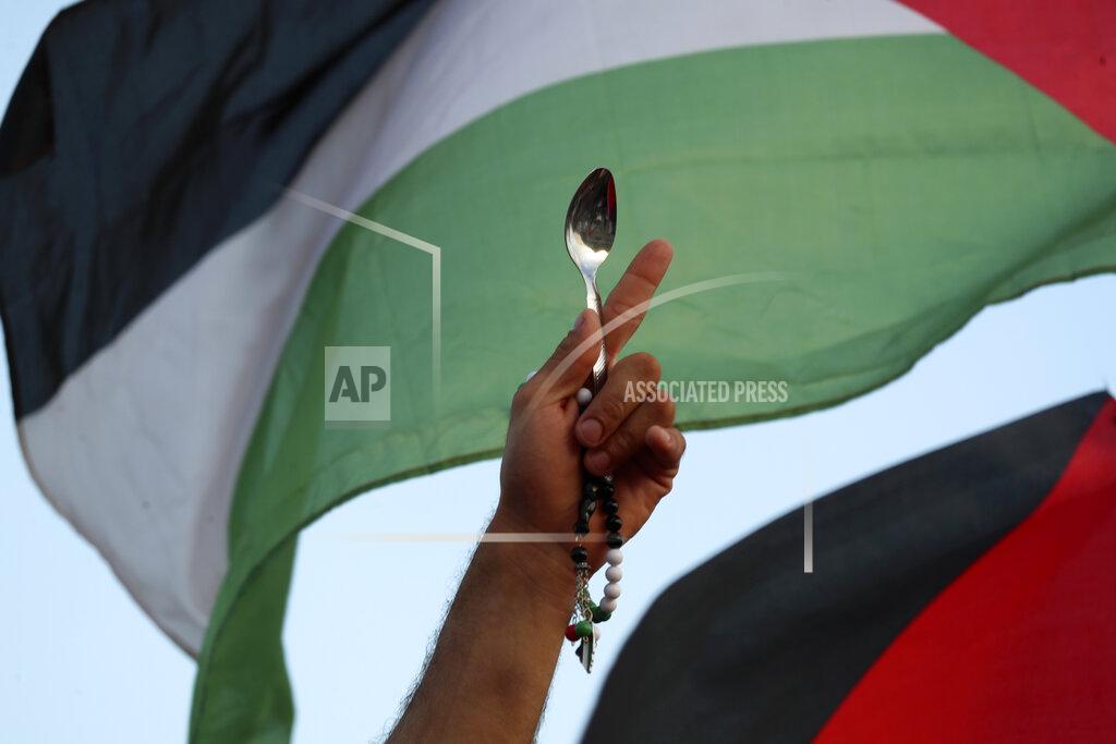 Ariel Schalit A protester holds a Palestinian flag and a spoon, which has become a symbol celebrating the six Palestinian prisoners who recently tunneled out of Gilboa Prison, in Umm el-Fahm, Israel, Friday, Sept. 10, 2021. (AP Photo/Ariel Schalit)