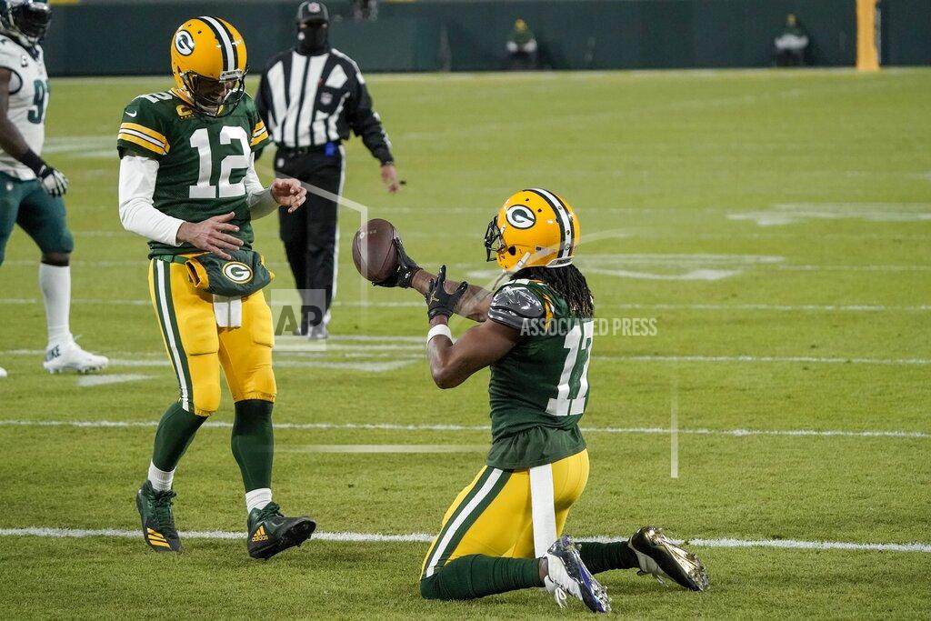 Morry Gash Green Bay Packers' Davante Adams hands the ball to quarterback Aaron Rodgers after catching a touchdown pass during the second half of an NFL football game against the Philadelphia Eagles Sunday, Dec. 6, 2020, in Green Bay, Wis. The pass was Rodgers' 400th career touchdown pass. (AP Photo/Morry Gash)