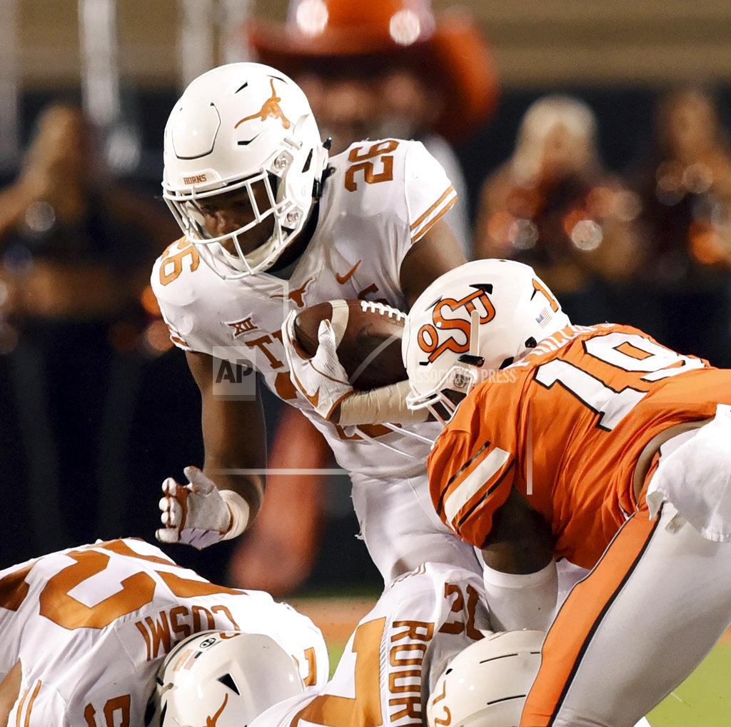 Brody Schmidt Texas running back Keaontay Ingram (26) struggles to get past Oklahoma State linebacker Justin Phillips (19) in the first half of an NCAA college football game in Stillwater, Okla., Saturday, Oct. 27, 2018. (AP Photo/Brody Schmidt)