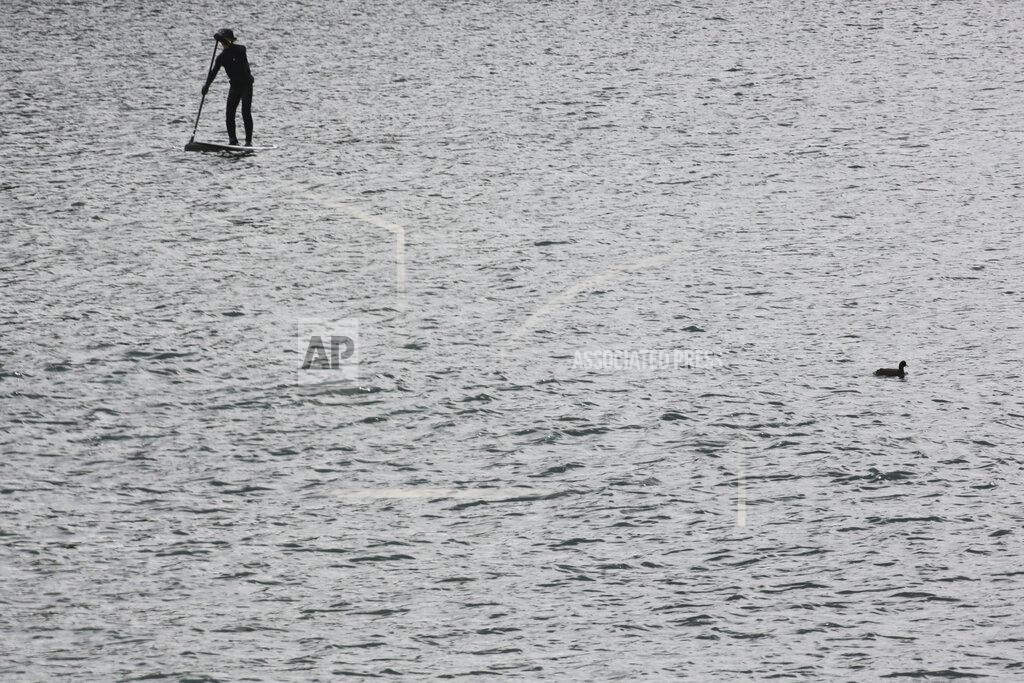 Koji Sasahara A man enjoys a paddleboard at Enoshima, the venue of sailing competitions at the Tokyo 2020 Olympics, in Fujisawa, near Tokyo, Tuesday, April 6, 2021. Many preparations are still up in the air as organizers try to figure out how to hold the postponed games in the middle of a pandemic. (AP Photo/Koji Sasahara)