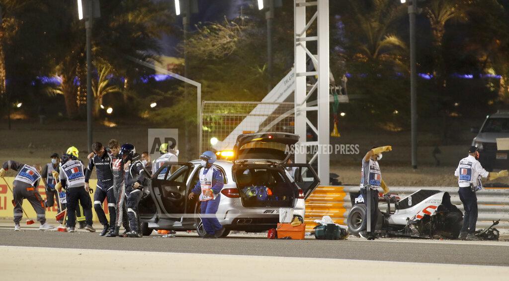 Hamad Mohammed Haas driver Romain Grosjean of France is helped by medical staff after he crashed his car during the Formula One race in Bahrain International Circuit in Sakhir, Bahrain, Sunday, Nov. 29, 2020. (Hamad Mohammed, Pool via AP)