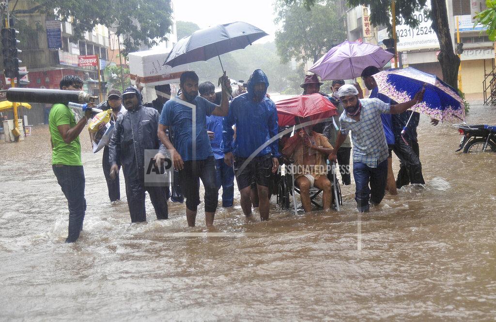 Uncredited A man wearing an oxygen mask is helped on a wheelchair through floodwaters in Kolhapur, in the western Indian state of Maharashtra, Friday, July 23, 2021. Landslides triggered by heavy monsoon rains hit parts of western India, killing more than 30 people and leading to the overnight rescue of more than 1,000 other people trapped by floodwaters, officials said Friday. (AP Photo)