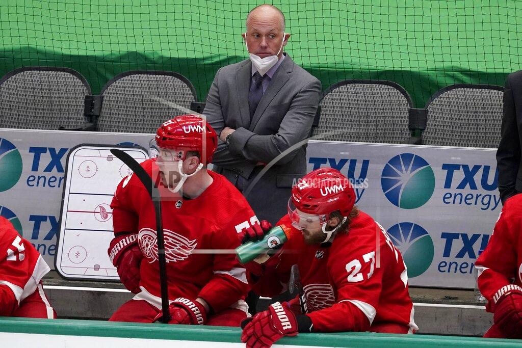 Tony Gutierrez File-This April 20, 2021, file photo shows Detroit Red Wings head coach Jeff Blashill, rear, Adam Erne (73) and Michael Rasmussen (27) watching play against the Dallas Stars. The Red Wings are sticking with Blashill for their rebuild. General manager Steve Yzerman made the announcement Tuesday, May 18, 2021, giving Blashill a contract extension despite a five-year postseason drought and a career record of 172-221-62. (AP Photo/Tony Gutierrez, File)