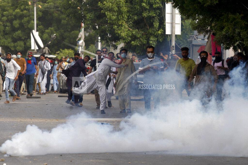 Fareed Khan Supporters of Pakistan's key opposition party throw stones toward police who fire tear gas to disperse them during an anti-government rally, in Karachi, Pakistan, Wednesday, May 25, 2022. Pakistani police have fired tear gas and scuffled with stone-throwing supporters of defiant former Prime Minister Imran Khan as they gathered for planned marches Wednesday toward central Islamabad for a rally he hopes will bring down the government and force early elections. (AP Photo/Fareed Khan)