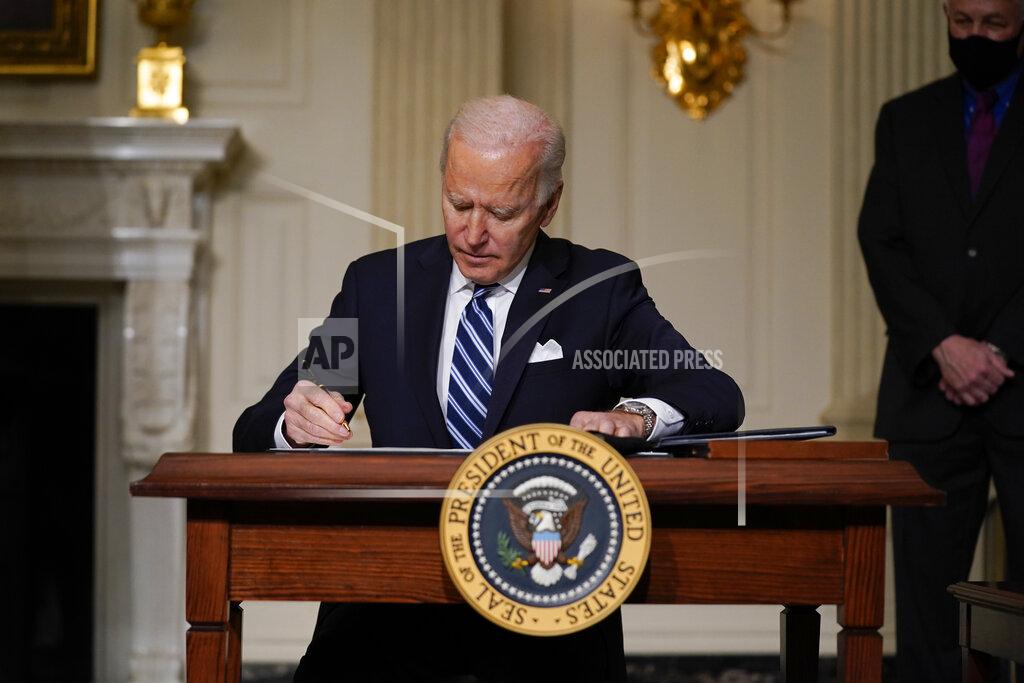 Evan Vucci President Joe Biden signs an executive order on climate change, in the State Dining Room of the White House, Wednesday, Jan. 27, 2021, in Washington. (AP Photo/Evan Vucci)