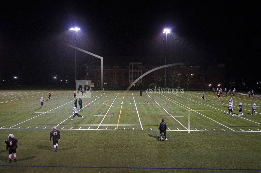 Players take part in drills under lights at the University of Puget Sound, Tuesday, Feb. 2, 2021, in Tacoma, Wash. For all the attention heaped on the FBS level of college football last fall as it tried to play, it will not be the only college football during the 2020-21 sports calendar as a handful of NCAA Division III and NAIA programs begin some form of a winter/spring season Saturday, Feb. 6. (AP Photo/Ted S. Warren)