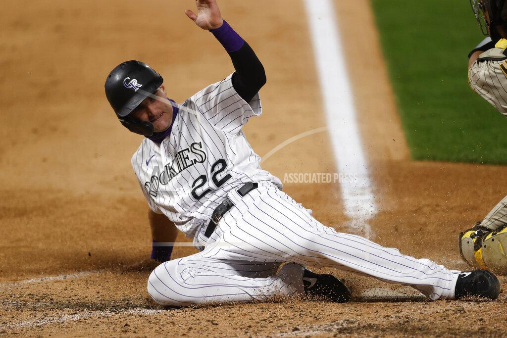David Zalubowski Colorado Rockies' Sam Hilliard, left, slides safely into home plate to score on a double hit by pinch hitter Matt Kemp as San Diego Padres catcher Austin Hedges turns to apply a alte tag in the sixth inning of a baseball game Friday, July 31, 2020, in Denver. (AP Photo/David Zalubowski)