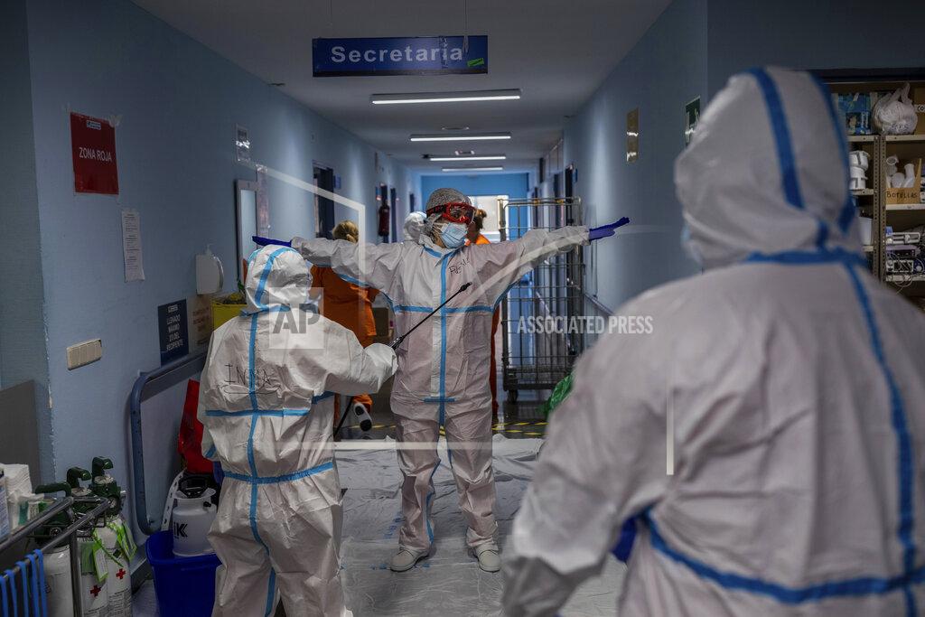 Bernat Armangue A medical team member is disinfected before leaving the COVID-19 ward at the Severo Ochoa hospital in Leganes, outskirts of Madrid, Spain, Friday, Oct. 9, 2020. At the peak of the first wave, ICU wards were given over to haste, desperation and even cluelessness about what to do. Now, a well-oiled machinery saves some lives and loses others to coronavirus, but without the doomsday atmosphere of March and April. (AP Photo/Bernat Armangue)