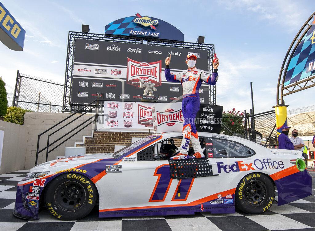 Jason Minto Denny Hamlin stands on his car after winning the NASCAR Cup Series auto race at Dover International Speedway, Saturday, Aug. 22, 2020, in Dover, Del. (AP Photo/Jason Minto)