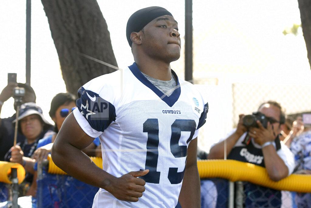 FILE - In this July 27, 2019, file photo, Dallas Cowboys wide receiver Amari Cooper jogs onto the field at the NFL football team's training camp in Oxnard, Calif. Dak Prescott pretends he can’t hear the question when the subject turns to a new contract for the star quarterback of the Dallas Cowboys, while receiver Amari Cooper steadfastly says he simply doesn’t think about what might be happening in his negotiations. Both reported to training camp on time as they prepare for the final year of their respective deals. (AP Photo/Michael Owen Baker, File)