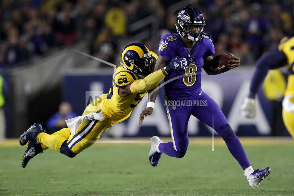 Baltimore Ravens quarterback Lamar Jackson, right, is tackled by Los Angeles Rams defensive end Dante Fowler during the second half of an NFL football game Monday, Nov. 25, 2019, in Los Angeles. (AP Photo/Marcio Jose Sanchez)