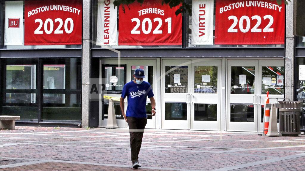 Charles Krupa FILE - In this July 23, 2020, file photo, Weston Koenn, a graduate student from Los Angeles, leaves the Boston University student union building in Boston. The university is urging students to stay on campus for Thanksgiving or, if they go home, stay away for the rest of the semester, joining a growing number of U.S. universities working to curb the spread of the coronavirus around the holidays. (AP Photo/Charles Krupa, File)