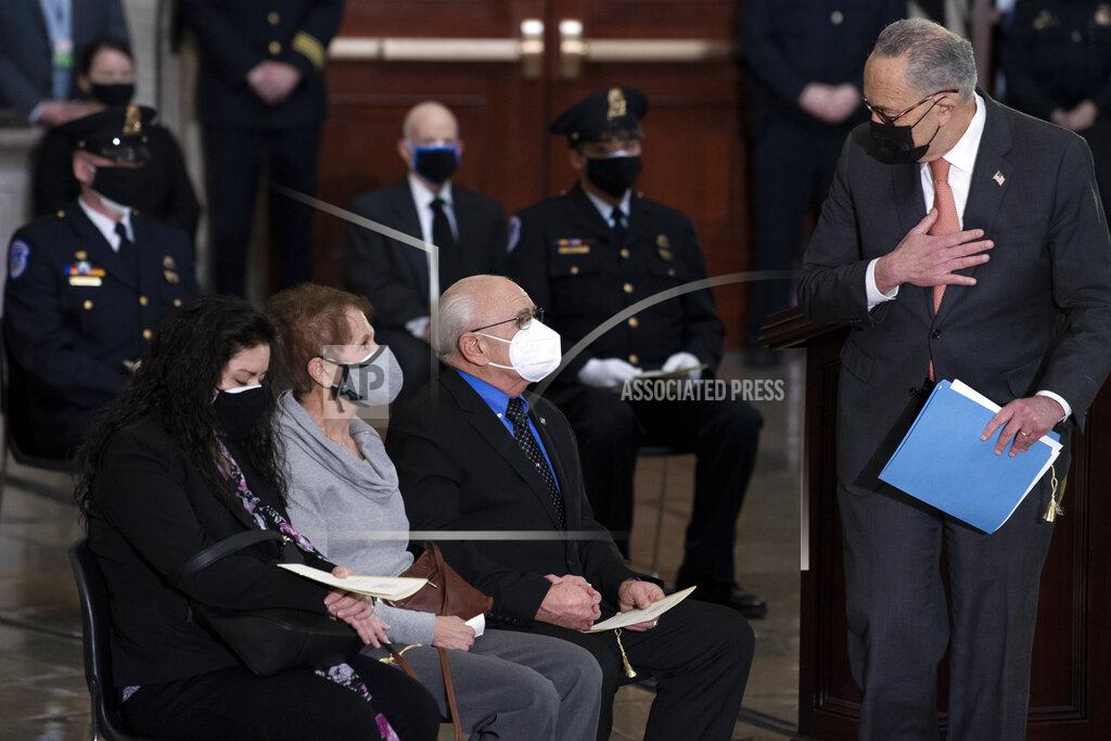 Brendan Smialowski Senate Majority Leader Chuck Schumer of New York, speaks to family during a ceremony memorializing U.S. Capitol Police officer Brian Sicknick, as an urn with his cremated remains lies in honor on a black-draped table at the center of the Capitol Rotunda, Wednesday, Feb. 3, 2021, in Washington.(Brendan Smialowski/Pool via AP)