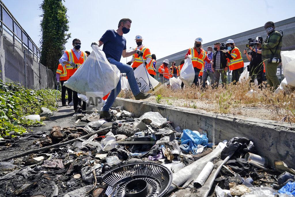 Marcio Jose Sanchez California Gov. Gavin Newsom, center, joins a cleanup effort Tuesday, May 11, 2021, in Los Angeles. Newsom on Tuesday proposed $12 billion in new funding to get more people experiencing homelessness in the state into housing and to "functionally end family homelessness" within five years. (AP Photo/Marcio Jose Sanchez)