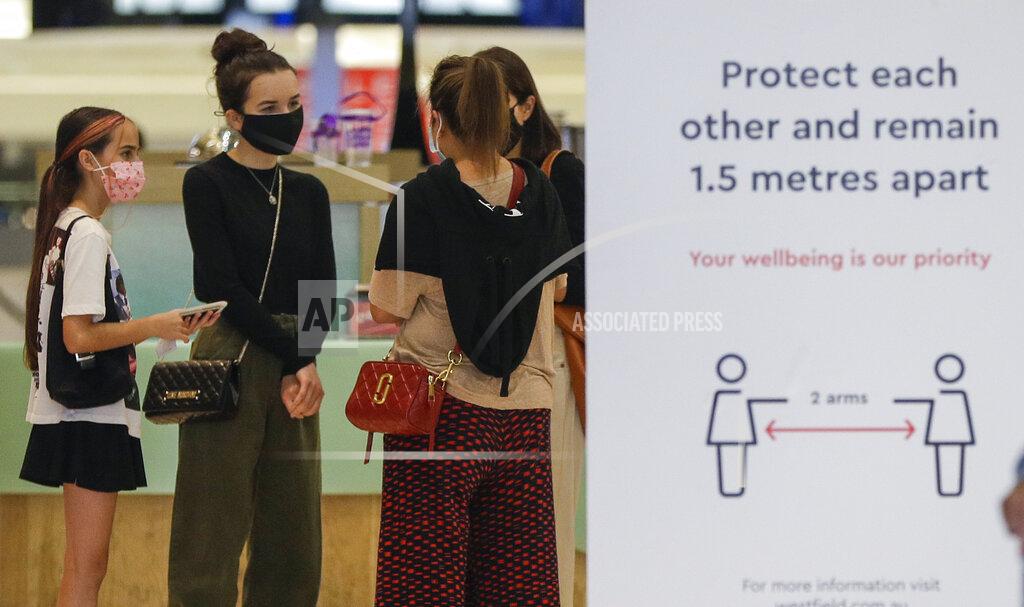 Mark Baker Shoppers wear masks as they walk around a shopping precinct in Sydney, Australia, Sunday, Jan. 3, 2021. Masks have been made mandatory in shopping centers, on public transport, in entertainment venues such as a cinema, and fines will come into effect on Monday as the state government responds to the COVID-19 outbreak on Sydney's northern beaches, which is suspected to have also caused new cases in neighboring Victoria state. (AP Photo/Mark Baker)
