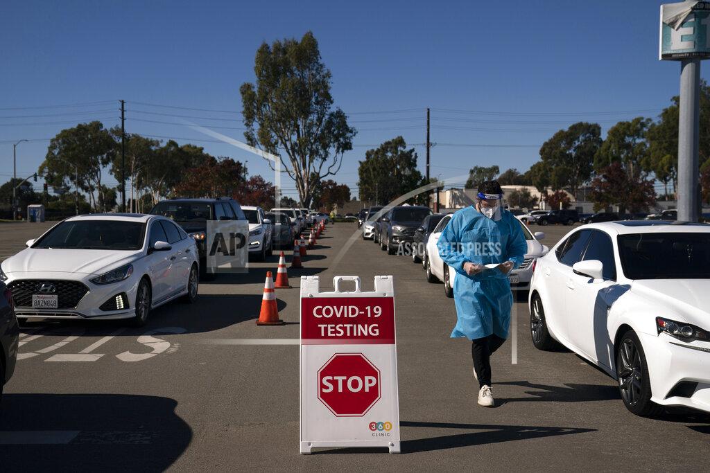 Jae C. Hong FILE - In this Nov. 16, 2020, file photo, student nurse Ryan Eachus collects forms as cars line up for COVID-19 testing at a testing site set at the Orange County Fairgrounds in Costa Mesa, Calif. California reported more than 20,000 new coronavirus cases on Wednesday, Dec. 2, 2020, shattering the previous record of 18,350 cases just a week ago. Overall, California has reported more than 1.2 million COVID-19 cases and more than 19,300 deaths. (AP Photo/Jae C. Hong, File)