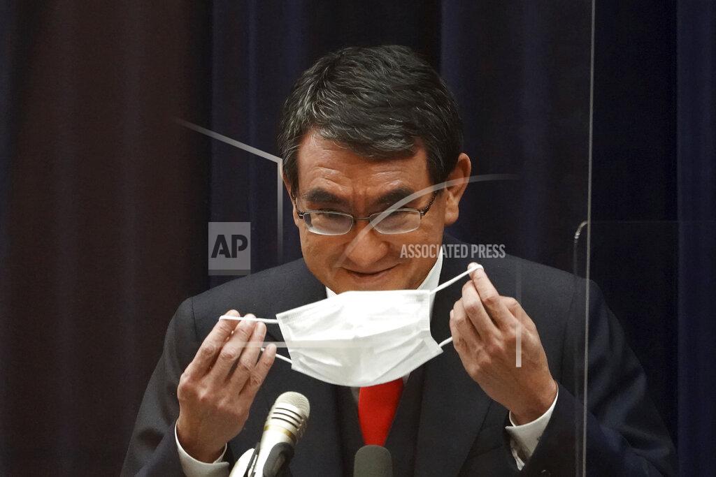Japan’s Administrative Reform Minister Taro Kono, who is also in charge of COVID-19 vaccines, puts his mask back on after a news conference in Tokyo on Tuesday, Feb. 16, 2021, on inoculations. Japan rolls out its vaccination campaign Wednesday, Feb. 17, after the government gave belated first approval to a shot co-developed by Pfizer Inc. that the U.S. and many other countries started using two months ago. Kono defended the delay. “It was more important for the government to show the Japanese people that everything was done” to encourage taking the vaccines, he said. (AP Photo/Eugene Hoshiko)