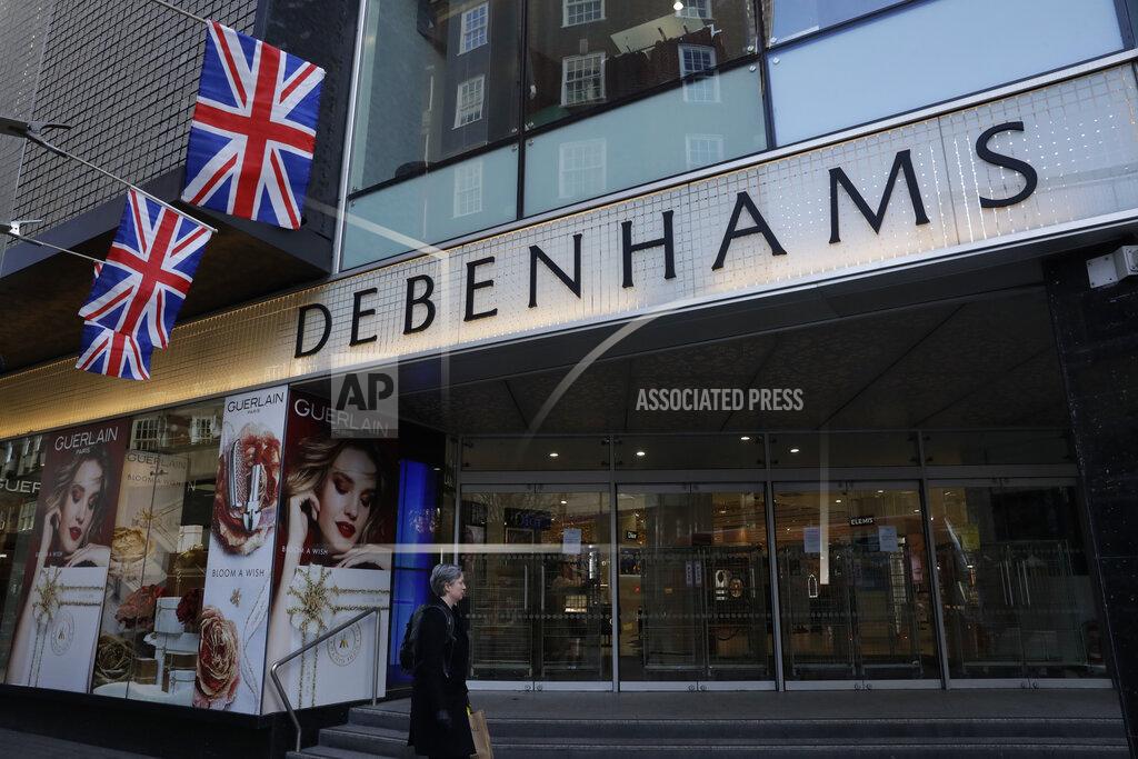 Matt Dunham A woman walks past the Debenhams flagship department store on Oxford Street, during England's second coronavirus lockdown in London, Tuesday, Dec. 1, 2020. In another dark day for the British retailing industry, Debenhams said Tuesday it will start liquidating its business after a potential buyer of the company pulled out, a move that looks like it will cost 12,000 workers their jobs. (AP Photo/Matt Dunham)