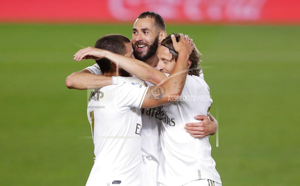 Manu Fernandez Real Madrid's Karim Benzema, center, celebrates with his teammates Eden Hazard, left, and Luka Modric after scoring his side's opening goal during the Spanish La Liga soccer match between Real Madrid and Valencia at Alfredo di Stefano stadium in Madrid, Spain, Thursday, June 18, 2020. (AP Photo/Manu Fernandez)