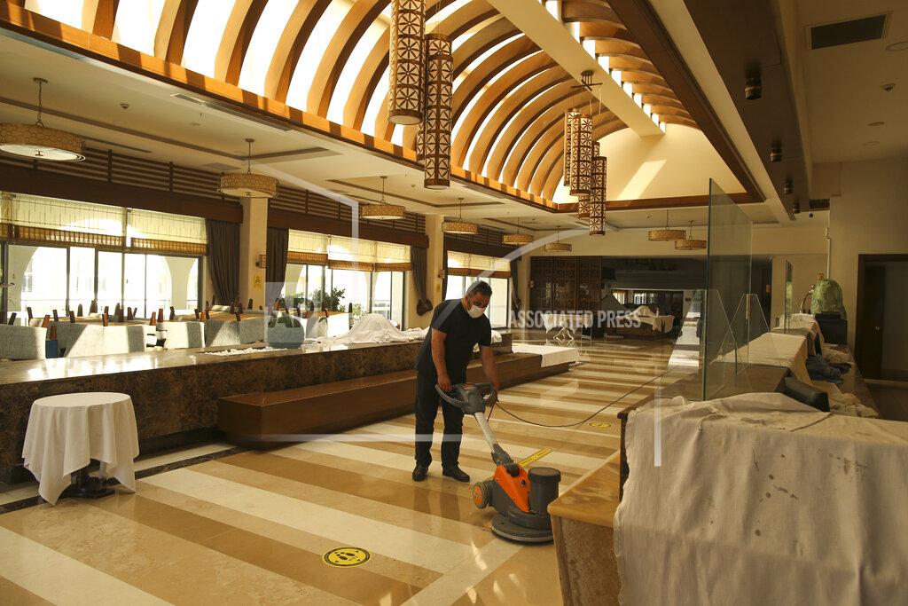 Emrah Gurel A hotel employee wearing a protective face mask cleans the floor of the reception in Antalya, southern Turkey, Saturday, June 19, 2021. Hotels in Turkey's Antalya region, a destination beloved by holidaymakers, are preparing to finally resume operations as they expect the return of international tourists after months of setbacks caused by the pandemic that halted travel. (AP Photo/Emrah Gurel)