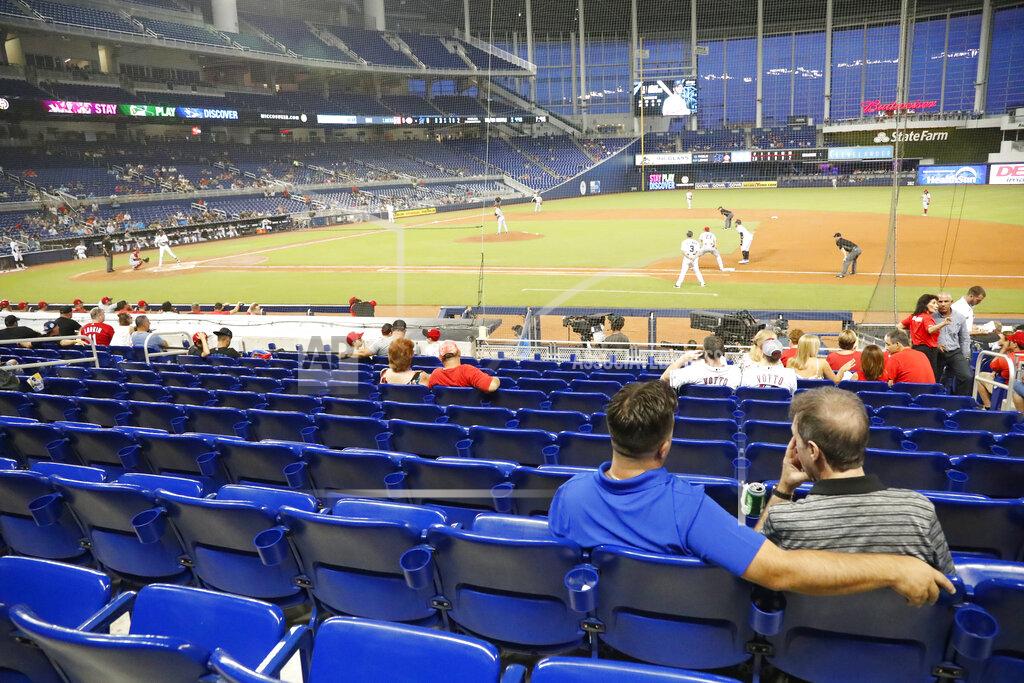 Wilfredo Lee FILE - In this Monday, Aug. 26, 2019 file photo, fans watch play among empty seats during the second inning of a baseball game between the Miami Marlins and the Cincinnati Reds in Miami. Many college and pro sports teams already were dealing with declining ticket sales. The improved at-home experience, the emergence of wide-spread legalized betting and the changing social makeup of fan bases have been catalysts, while dynamic pricing, increases in parking and concession prices and a push toward luxury seating have exacerbated the problem. (AP Photo/Wilfredo Lee, File)