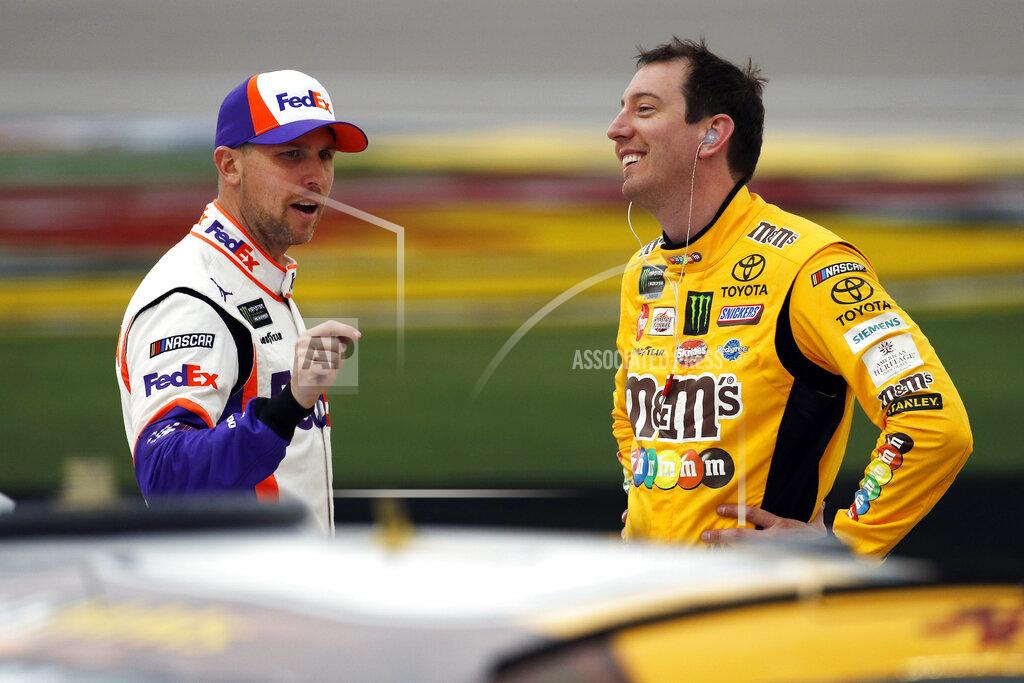 John Locher FILE - In this March 1, 2019, file photo, drivers Denny Hamlin, left, and Kyle Busch talk in pit lane before qualifying for the NASCAR Cup Series auto race at Las Vegas Motor Speedway in Las Vegas. Hamlin has all the momentum headed into the third round of NASCAR's playoffs, which start Sunday at Martinsville Speedway. But hot on his bumper are his Joe Gibbs Racing teammates, regular season champion Kyle Busch and Martin Truex Jr., who leads the series with six wins this season.(AP Photo/John Locher, File)