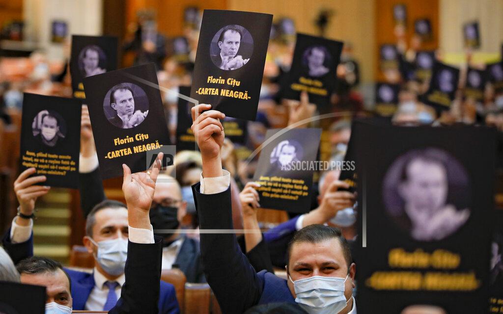 Vadim Ghirda Opposition members of parliament hold leaflets showing prime minister-designate Florin Citu, reading "The Black Book" during a session called to vote on the government team in Bucharest, Romania, Wednesday, Dec. 23, 2020. Romania's president Klaus Iohannis appointed on Tuesday, the outgoing finance minister as prime minister-designate after three pro-Western center-right groups joined forces to keep out of power a left-leaning populist party that won most votes at a parliamentary election earlier this month. (AP Photo/Vadim Ghirda)