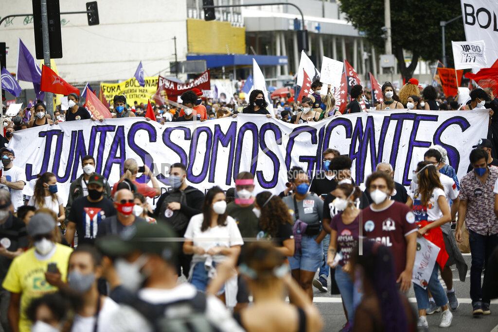Bruna Prado People march holding a banner with a message that reads in Portuguese; "Together, we are giants" during a demonstration against Brazilian President Jair Bolsonaro's handling of the coronavirus pandemic and economic policies protesters say harm the interests of the poor and working class, in Rio de Janeiro, Brazil, Saturday, June 19, 2021. Brazil is approaching an official COVID-19 death toll of 500,000 — second-highest in the world. (AP Photo/Bruna Prado)