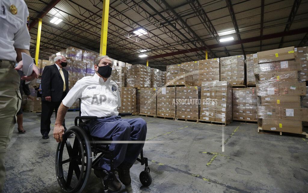 Eric Gay Texas Gov. Greg Abbott, left,, and other officials visit a Texas Division of Emergency Management Warehouse filled with Personal Protective Equipment, Tuesday, Aug. 4, 2020, in San Antonio. (AP Photo/Eric Gay)