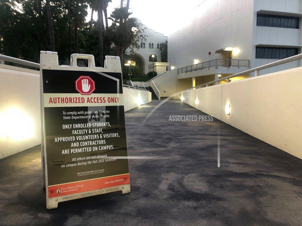 This Sept. 17, 2020, photo shows a sign for "Authorized Access Only" for visitors to the San Diego State University campus in San Diego, Calif. A coronavirus outbreak of more than 700 cases reported at San Diego State University has put all of San Diego County, with more than 3 million people, at risk of having to close indoor dining and shopping, many for a third time under California guidelines. (AP Photo/Elliot Spagat)