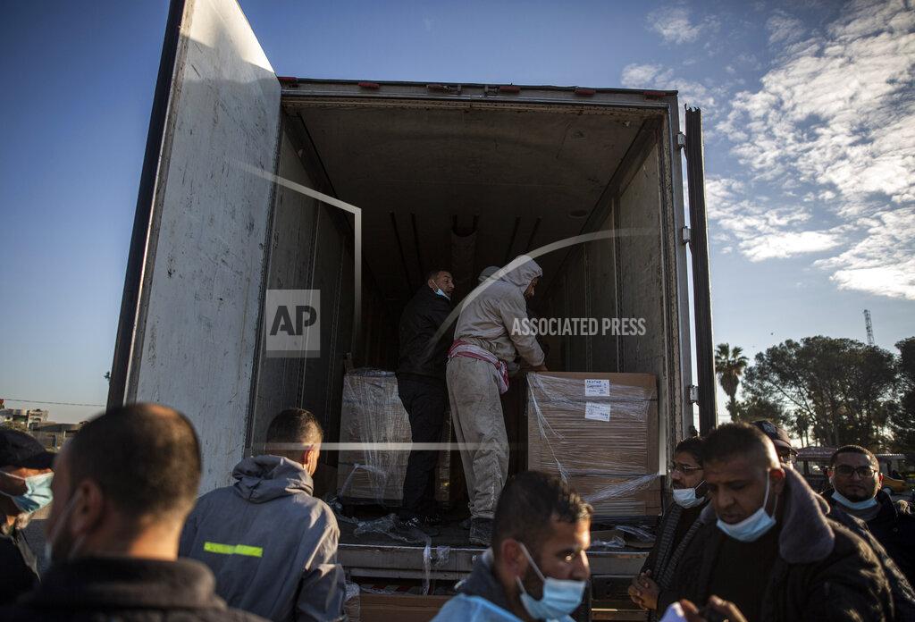 Khalil Hamra Palestinian workers unload a truck from 20,000 doses of Russian-made Sputnik V vaccine upon its arrival to Gaza Strip, at the Rafah crossing border with Egypt, Sunday, Feb. 21, 2021. The 20,000 doses of Russia's Sputnik V, donated by the United Arab Emirates and organized by Abbas rival Mohammed Dahlan, entered the Palestinian enclave through its border with Egypt. (AP Photo/Khalil Hamra)