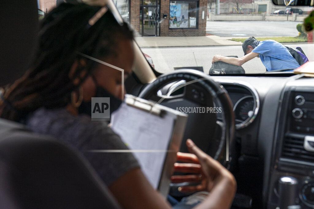 David Goldman Larrecsa Cox, who leads the Quick Response Team, sits in her car with a list of people to visit after giving a man on the street a supply of the overdose reversal medication naloxone to carry on him in Huntington, W.Va., Wednesday, March 17, 2021. The team tries to track down everyone who overdosed, searching for them in abandoned houses and tent encampments on the river, at half-million-dollar homes on the golf course, out on the rural roads that wind toward the mountains. If the people they find are ready for treatment, they get them there. If they aren't, they try to help them survive in the meantime. (AP Photo/David Goldman)