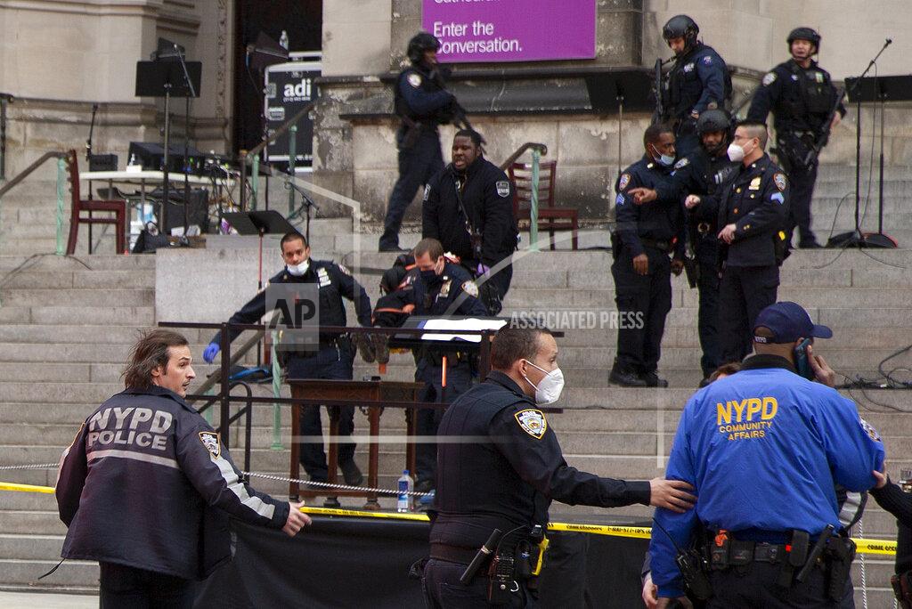 Ted Shaffrey New York police officers carry a suspected gunman in a stretcher down the steps of Cathedral Church of St. John the Divine, Sunday, Dec. 13, 2020, in New York. A man was shot by police after shots rang out at the end of a Christmas choral concert on the steps of the Manhattan cathedral Sunday afternoon. It's unclear if the gunman was killed or if any others were injured. The shooting happened just before 4 p.m. at the church which is the mother church of the Episcopal Diocese of New York and seat of its bishop. (AP Photo/Ted Shaffrey)