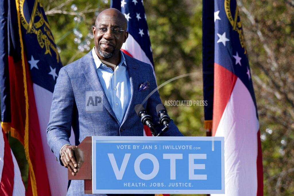 Ben Gray Democratic U.S. Senate challenger the Rev. Raphael Warnock speaks during a rally, Monday, Dec. 21, 2020 in Columbus, Ga. with Vice President-Elect Kamala Harris and fellow Democratic U.S. Senate challenger Jon Ossoff. (AP Photo/Ben Gray)