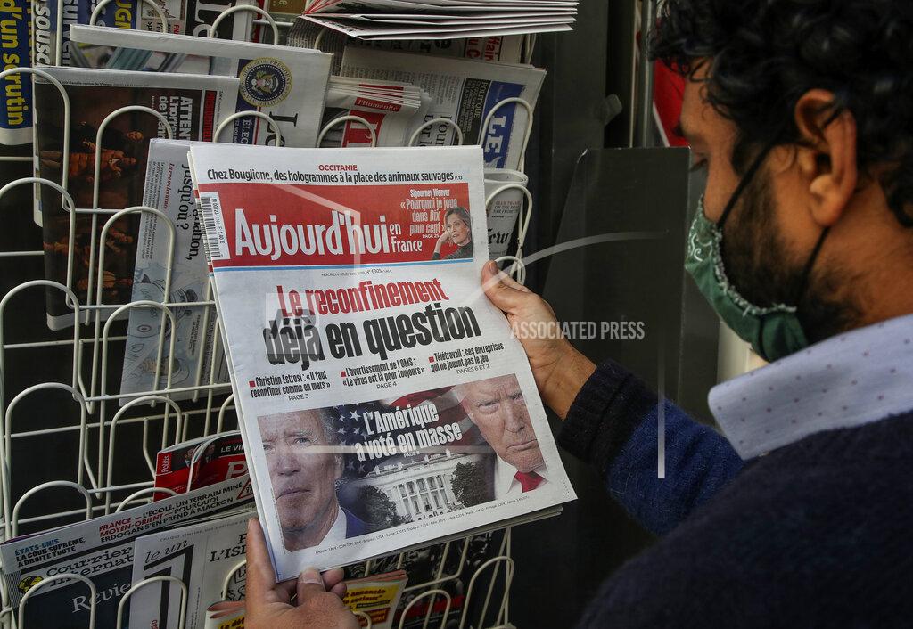 Michel Euler A man wearing a face mask as a precaution against the coronavirus reads the headlines about the U.S. presidential elections at a newspapers stand in Paris, Wednesday, Nov. 4, 2020. The world is watching as millions of Americans cast their ballots for the next president on Tuesday. (AP Photo/Michel Euler)
