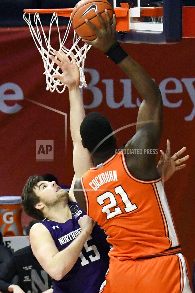 Holly Hart Illinois center Kofi Cockburn (21) puts the ball in as Northwestern's center Ryan Young (15) defends in the first half of an NCAA college basketball game Tuesday, Feb. 16, 2021, in Champaign, Ill. (AP Photo/Holly Hart)